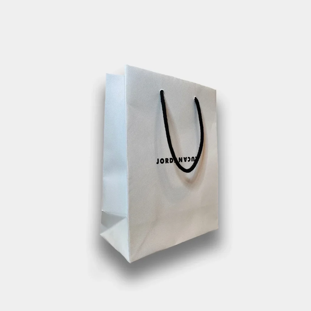 White paper carrier bag with black string handle